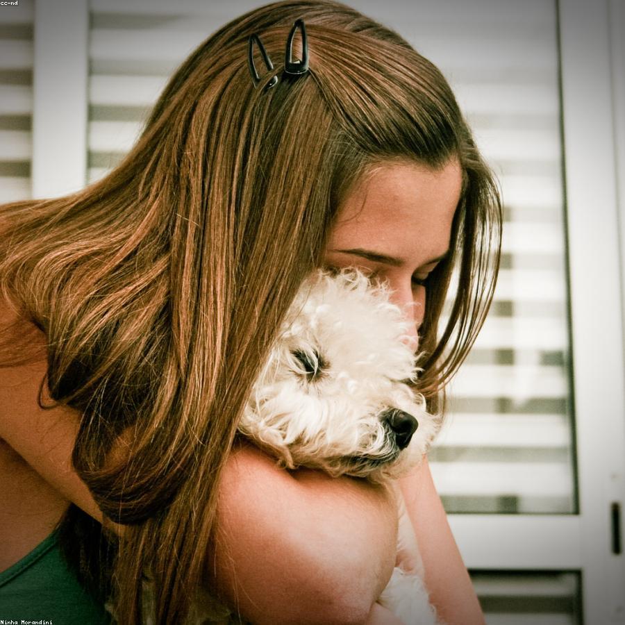Mulher abraçando carinhosamente seu cachorro